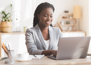 Smiling african american businesswoman working on laptop.