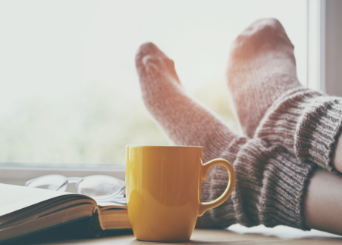 Feet propped up with a book and mug