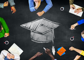 People sitting around a table with graduation cap drawn in chalk