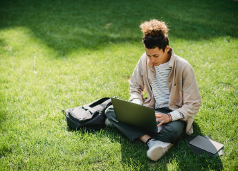 College student studying alone in campus grass area