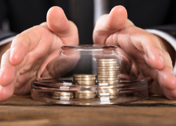 Hands holding out money under a clear glass bowl