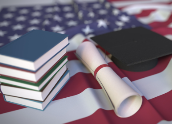 Diploma, graduation cap, and books on an American flag