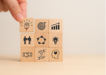 Hand stacking blocks with icons for ideas, success, leaders, etc